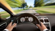 Man in suit driving a car from vehicle interior